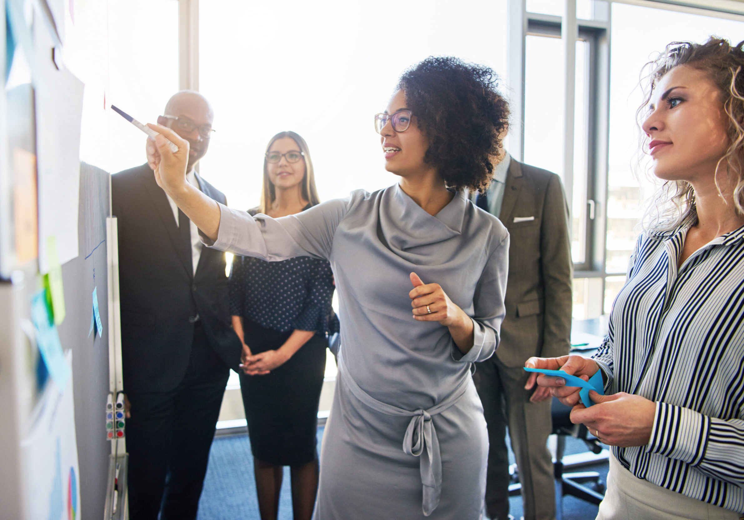 Diverse,Group,Of,Focused,Businesspeople,Brainstorming,Together,On,A,Whiteboard